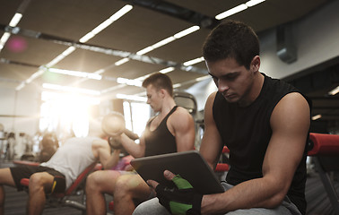 Image showing group of men with tablet pc and dumbbells in gym