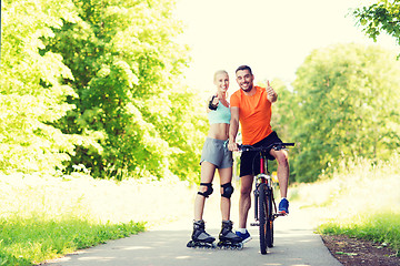 Image showing couple on rollerblades and bike showing thumbs up