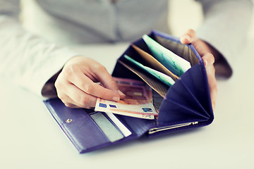 Image showing close up of woman hands with wallet and euro money