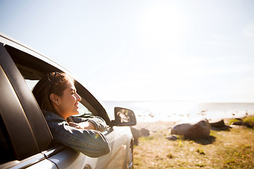 Image showing happy teenage girl or young woman in car