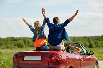 Image showing happy friends driving in cabriolet car at country