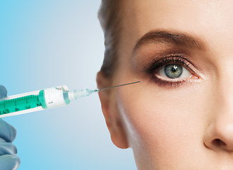 Image showing woman face and hand with syringe making injection