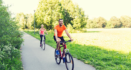 Image showing happy couple riding bicycle outdoors