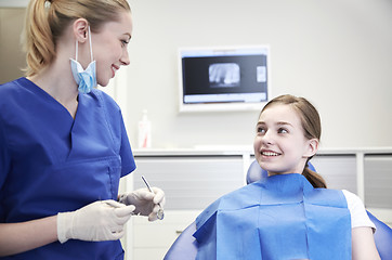 Image showing female dentist checking patient girl teeth