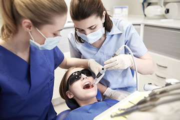 Image showing female dentists treating patient girl teeth