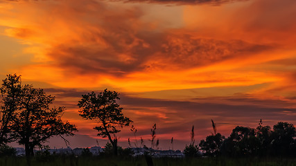 Image showing Landscape with dark orange and yellow stormy cloudy sky