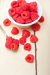 Image showing bunch of fresh raspberry on a bowl and white table