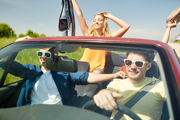 Image showing happy friends driving in cabriolet car