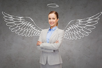 Image showing happy businesswoman with angel wings and nimbus