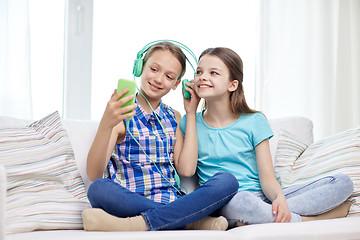 Image showing happy girls with smartphone and headphones