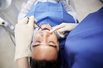 Image showing close up of dentist checking male patient teeth