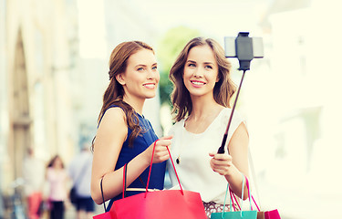 Image showing happy women with shopping bags and smartphone