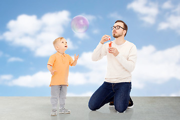 Image showing father with son blowing bubbles and having fun