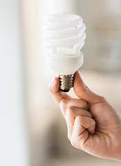 Image showing close up of hand holding energy saving lightbulb