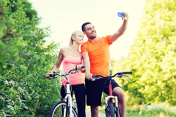 Image showing couple with bicycle taking selfie by smartphone