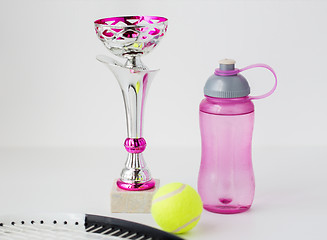 Image showing close up of tennis racket, ball, cup and bottle