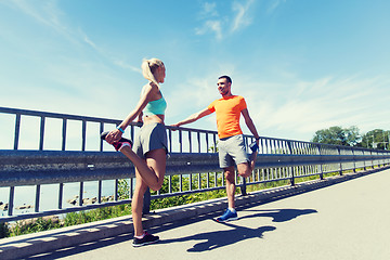 Image showing smiling couple stretching outdoors