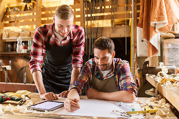 Image showing workmen with tablet pc and blueprint at workshop