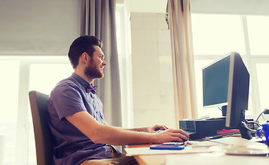 Image showing happy creative male office worker with computer