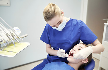 Image showing female dentist checking patient girl teeth