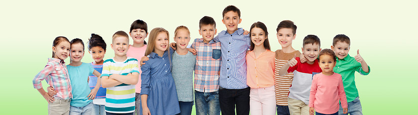 Image showing group of happy smiling children hugging over green