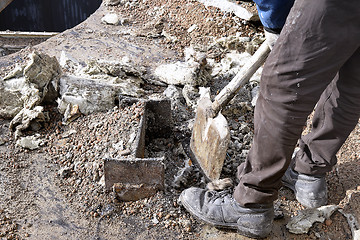 Image showing Unknown worker with a shovel clearing construction debris