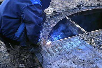 Image showing Work performs welding for metal outdoors