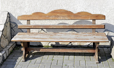 Image showing Old wooden vintage empty bench standing on an open paved area