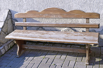 Image showing Old wooden vintage empty bench standing on an open paved area