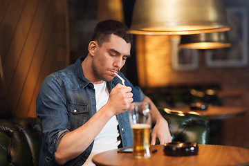 Image showing man drinking beer and smoking cigarette at bar