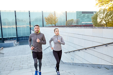 Image showing happy couple running upstairs on city stairs