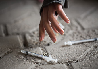 Image showing close up of addict woman hands and drug syringes