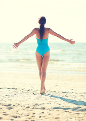 Image showing young woman in swimsuit posing on beach