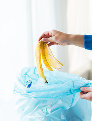 Image showing close up of hand putting food waste to rubbish bag