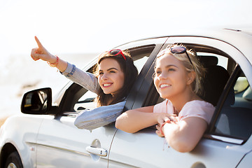 Image showing happy teenage girls or women in car at seaside