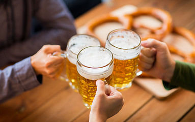 Image showing close up of hands with beer mugs at bar or pub