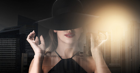 Image showing beautiful woman in black hat over dark background