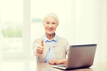 Image showing happy senior woman with laptop showing thumbs up