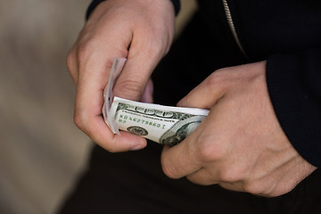 Image showing close up of addict or drug dealer hands with money