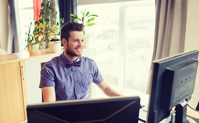 Image showing happy creative male office worker with computer