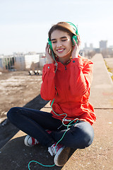 Image showing happy young woman in headphones listening to music