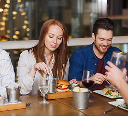 Image showing man with smartphone and friends at restaurant