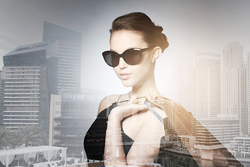 Image showing happy woman in black sunglasses with shopping bags