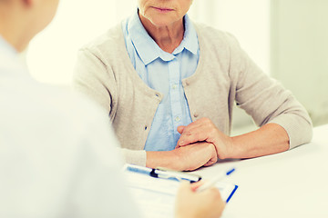 Image showing close up of senior woman and doctor with clipboard