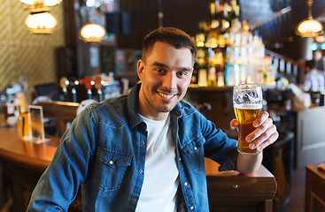 Image showing happy man drinking beer at bar or pub