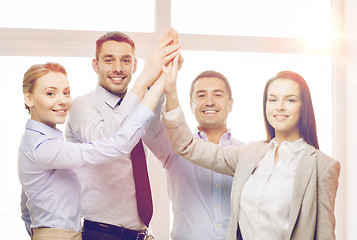 Image showing happy business team giving high five in office