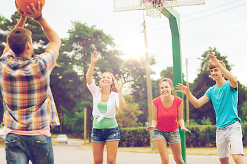 Image showing group of smiling teenagers playing basketball