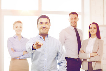 Image showing businessman in office pointing finger at you