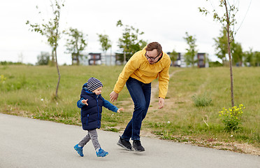 Image showing happy father and little son walking outdoors