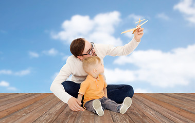 Image showing father and little son playing with toy airplane